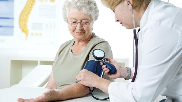 [Translate to Estonia - estonian:] Doctor taking a woman’s blood pressure